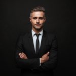 Handsome,Confident,Businessman,Wearing,Suit,Standing,Isolated,Over,Black,Background,